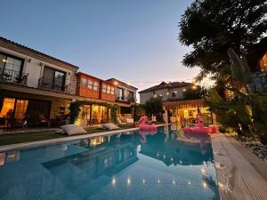 a swimming pool with pink inflatable flamingos in it at MorAnka Alaçatı in Alacati
