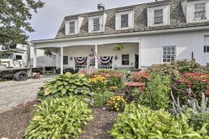 una casa blanca con una bandera americana y un jardín en Charming Farmhouse with Pool and Fishing Pond!, en Bolton