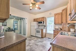 a kitchen with wooden cabinets and a ceiling fan at The Shady Cottage Millersburg Getaway with Deck in Millersburg