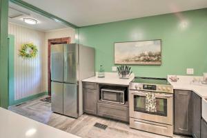 a kitchen with green walls and stainless steel appliances at 2 Mi to Central Ave Quaint Hot Springs Home! in Hot Springs