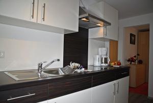 a kitchen with white cabinets and a sink at Aqua Marina in Helgoland