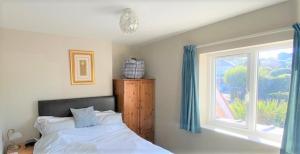 - une chambre avec un lit et une fenêtre dans l'établissement Cliff Court Apartments, à Torquay
