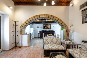 a living room with an archway and a kitchen at Aroni Cretan comfortable house - Hamam suites Aroni in Arónion +21 photos