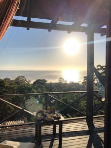 a table on a balcony with a view of the ocean at La Roca Studio 6 in Praia do Rosa +6 photos