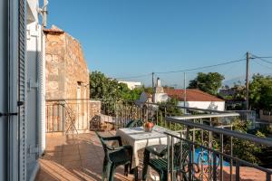 un patio con tavolo e sedie sul balcone. di Aroni Cretan comfortable house - Hamam suites Aroni a Arónion