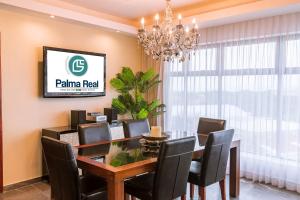 a dining room with a table and chairs and a chandelier at Hotel Palma Real in San José