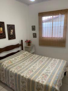 Un dormitorio con una cama con una manta. en Chalé beira mar Jacaraipe en Serra