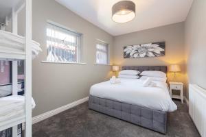 a bedroom with a bed and two bunk beds at Ashton Mews apartment with free parking in Saint Annes on the Sea