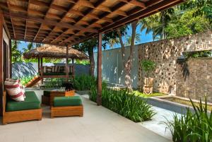 an outdoor patio with chairs and a umbrella at The Chandi Boutique Resort & Spa in Senggigi