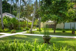 a garden with a plant in a pot in the grass at The Chandi Boutique Resort & Spa in Senggigi