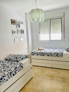 a bedroom with two beds and a chandelier at UIM Mediterraneo FELIPE 8 WIFI in Puerto de Sagunto