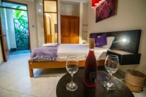 una bottiglia di vino e due bicchieri su un tavolo in una camera da letto di Bubinzana Magical Lodge a Tarapoto