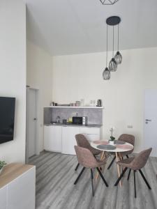 eine Küche mit einem Tisch und Stühlen im Zimmer in der Unterkunft Eden City Home in Győr