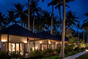 a resort with palm trees at night at The Chandi Boutique Resort & Spa in Senggigi