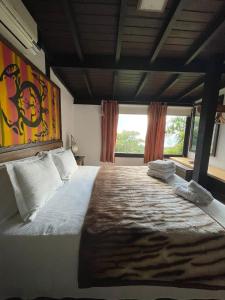a bedroom with a large bed with pillows on it at La Roca Studio 7 in Praia do Rosa