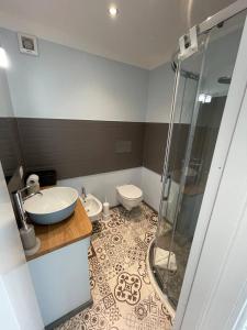 uma casa de banho com um chuveiro, um lavatório e um WC. em Gaias Rooms em Olbia