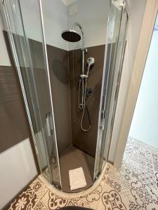 La salle de bains est pourvue d'une douche avec une porte en verre. dans l'établissement Gaias Rooms, à Olbia