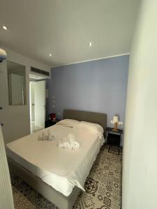 a bedroom with a bed with two towels on it at Gaias Rooms in Olbia
