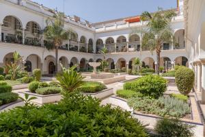 un cortile di un edificio con alberi e piante di Avanti Luz de Sevilla, hazte un regalo y disfrutalo a Siviglia