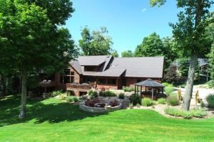 a log cabin with a porch and a yard at Edelweiss Lodge in Boyne Falls