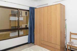 クリェラにあるEstirpe, 4º-8の木製のキャビネットと窓が備わる客室です。