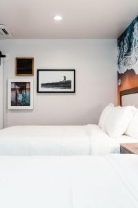 um sofá branco num quarto com fotografias na parede em Del Mar Beach Hotel em San Diego