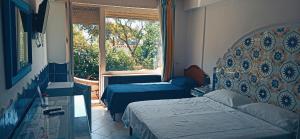 a bedroom with two beds and a window at Hotel 4 Stagioni in Capri