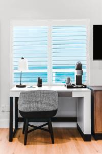 a white desk with a chair and a window at Del Mar Beach Hotel in San Diego