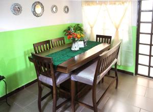 una mesa de comedor con sillas y una pared verde en Hermoso Departamento en Texcoco centro con wifi cocina, en Texcoco de Mora