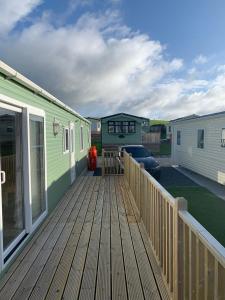 a wooden deck with a house and a car on it at Immaculate 2-Bed Lodge in Monreith in Newton Stewart