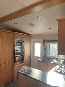 a kitchen with a sink and a stove top oven at Immaculate 2-Bed Lodge in Monreith in Newton Stewart