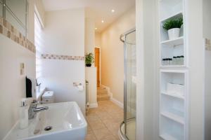 La salle de bains est pourvue d'un lavabo et d'une douche en verre. dans l'établissement Spring Villa, à Leicester