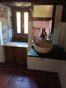 une personne prenant une photo d'un lavabo dans une salle de bains dans l'établissement Prieuré Saint Marcel, à Fleurey-sur-Ouche