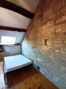 Cette chambre dispose d'un lit dans un mur en briques. dans l'établissement Prieuré Saint Marcel, à Fleurey-sur-Ouche