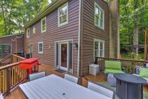 a tiny house with a deck with a table at Secluded Leesburg Retreat with Private Hot Tub! in Middleburg