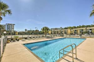 einen Pool mit Palmen und Gebäuden in der Unterkunft Updated PCB Resort Townhome - Walk to Beach! in Panama City Beach