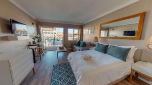 a bedroom with a bed and a living room at ShipsBell 5B in St Francis Bay