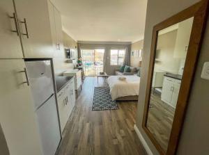 een keuken met een wastafel en een bed in een kamer bij ShipsBell 5B in St Francis Bay