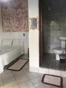 a bathroom with a bed and a sink and a toilet at Pousada Vila Cintra in Pirenópolis