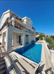 uma casa com piscina em frente a uma casa em Villa Mare Apartments em Tivat