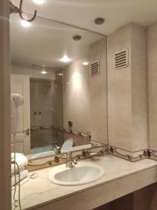 a bathroom with a sink and a large mirror at HR Esmeralda Luxor in Buenos Aires