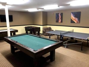 two ping pong tables in a room with two tables at King Bed Condo at Cedar Breaks Lodge in Brian Head
