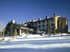 a large building with snow in front of it at King Bed Condo at Cedar Breaks Lodge in Brian Head