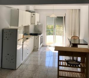 a kitchen with a refrigerator and a table in it at Hidden Gem Apartment in Neoi Epivates