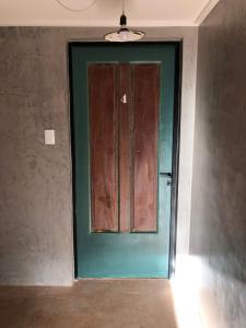 una puerta verde en una habitación con pared en Azul en Lavalle 4 en Azul
