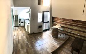 a kitchen with wooden floors and a table and a counter at Azul en Lavalle 4 in Azul