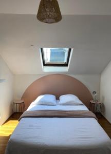 een slaapkamer met een groot bed en een raam bij Troisieme du nom in Nevers