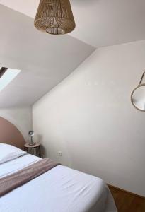een slaapkamer met een bed en een witte muur bij Troisieme du nom in Nevers