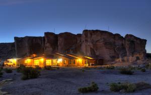 een gebouw midden in een woestijn 's nachts bij Hotel Mallku Cueva 