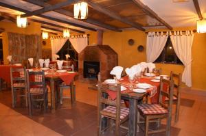 een eetkamer met tafels en stoelen en een open haard bij Hotel Mallku Cueva 